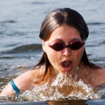 Female athlete is swimming with brass technique